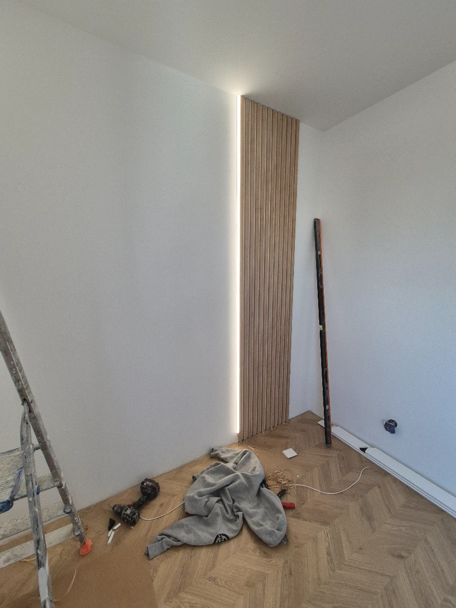 Panele ścienne z podświetleniem LED zamontowane w kącie pokoju podczas wykończenia wnętrza