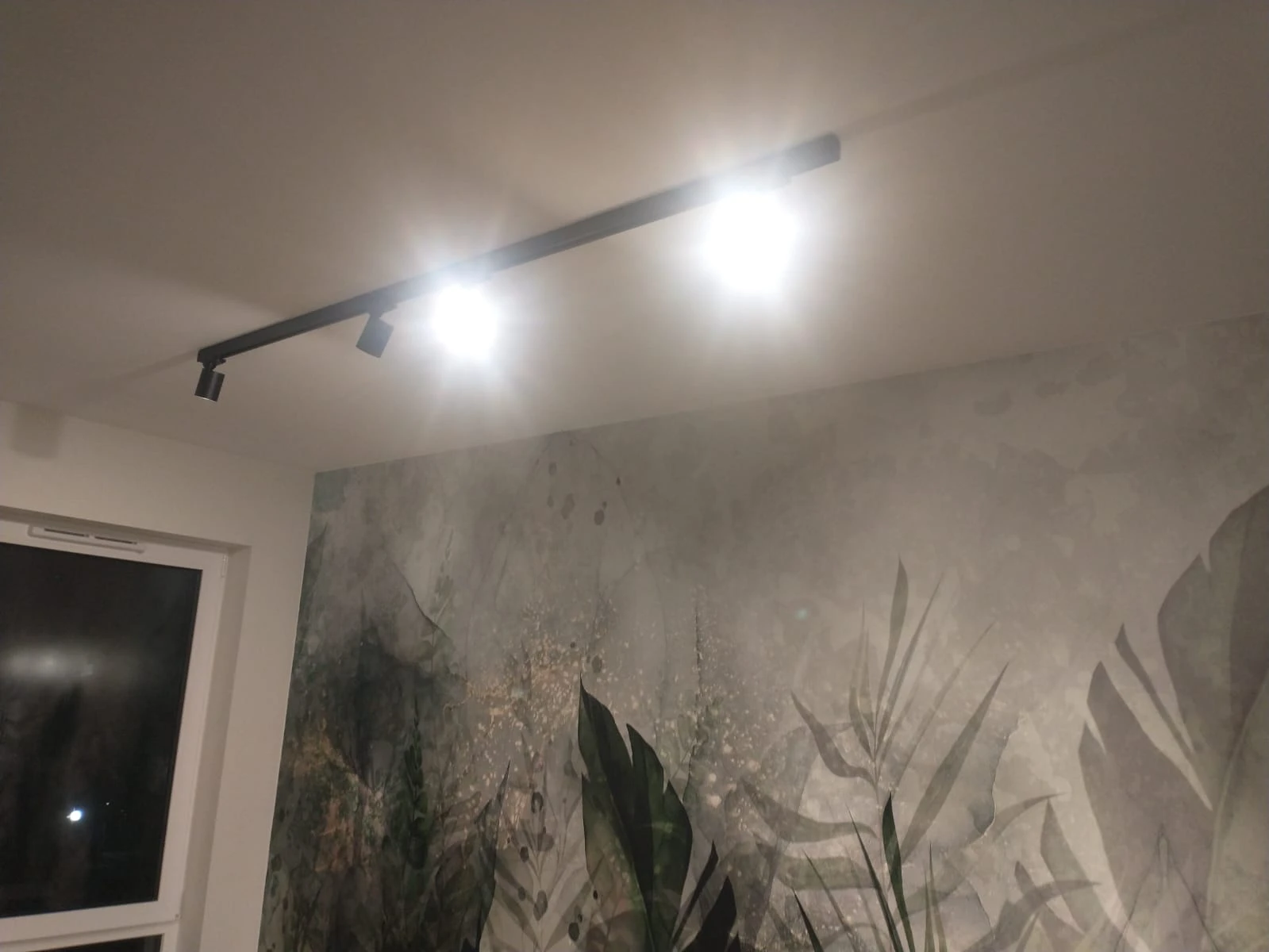 Oświetlenie sufitowe na szynie i dekoracyjna ściana z tapetą w motyw liści – Tapetowanie