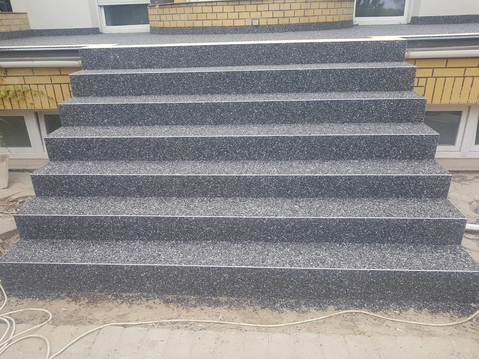 Nowoczesne schody zewnętrzne wykończone spiekami kwarcowymi w odcieniach grafitu