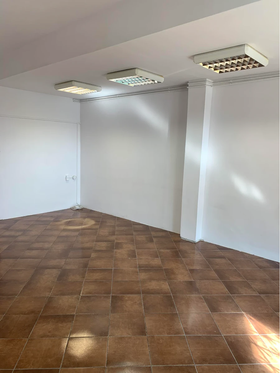 Pusty pokój z nową podłogą z brązowych płytek wielkoformatowych i białymi ścianami